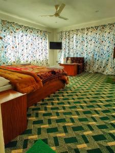 a bedroom with a bed and a television in it at Tip Top Pahalgam in Pahalgām