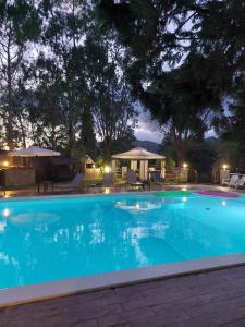 a large swimming pool at night with a gazebo at VILLA STRAVANATA - Large Pool, Car and Large Whirlpool Jacuzzi in San Gregorio +34 photos