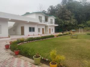 a white house with a lawn in front of it at Great Tiger Resort in Belparāo