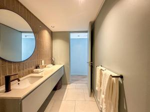a bathroom with a sink and a mirror at Home Suite Hotels De Waterkant in Cape Town