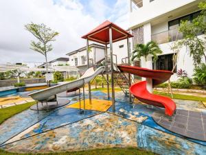 un parque infantil con un tobogán en un patio en Lovina B/22 at The Home Southlink, en Nagoya