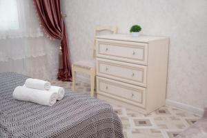 um quarto com uma cama e uma cómoda com toalhas em ЖК Шахристан 195 em Almaty