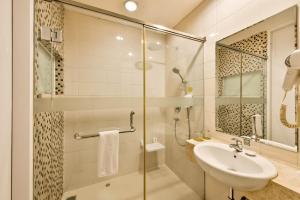 a bathroom with a glass shower and a sink at Maxone Premier Melawai in Jakarta