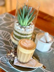 a cup of coffee on a plate on a table at Kaijaiki Country Inn and Restaurant in Yzerfontein