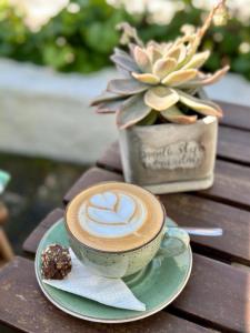 a cup of coffee on a plate on a table at Kaijaiki Country Inn and Restaurant in Yzerfontein