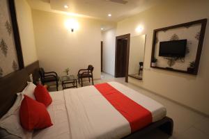 a hotel room with a bed and a television at Hotel Saishree` in Shirdi
