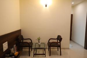 a waiting room with three chairs and a table at Hotel Saishree` in Shirdi