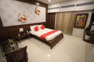 a bedroom with a bed and a table and chairs at Hotel Saishree` in Shirdi