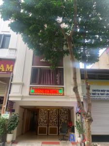 a building with a tree in front of it at Hoàng Gia Long Biên Hotel in Hanoi