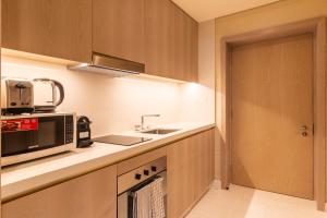 a kitchen with a sink and a microwave at The Palm Tower in Dubai