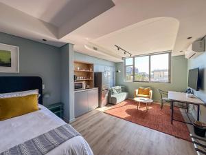um quarto com uma cama e uma sala de estar em Home Suite Hotels De Waterkant em Cidade do Cabo