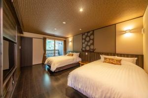 pokój hotelowy z 2 łóżkami i telewizorem w obiekcie 史跡旅館 花月大正館 w mieście Takeo