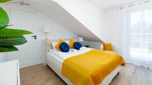 a bedroom with a bed with yellow and blue pillows at Wonder Home - Apartamenty z widokiem na góry, blisko wyciągów, szlaków turystycznych i restauracji in Karpacz