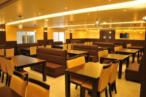 a restaurant with tables and chairs in a room at HOTEL RUBY PALACE in Tiruchirappalli