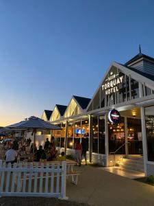een groep mensen die buiten een gebouw zitten bij Torquay Hotel/Motel in Torquay