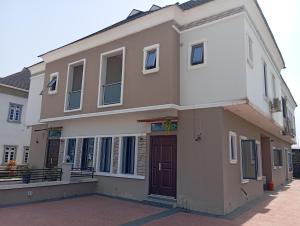 uma grande casa branca com uma porta castanha em Frontline Homes & Suites 3bedroom Apartment em Lekki