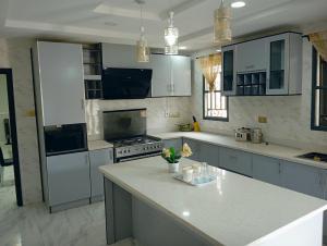 uma cozinha com armários brancos e um balcão branco em Frontline Homes & Suites 3bedroom Apartment em Lekki