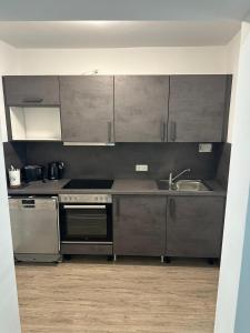 a kitchen with stainless steel appliances and a sink at Neckar-Apart in Heilbronn
