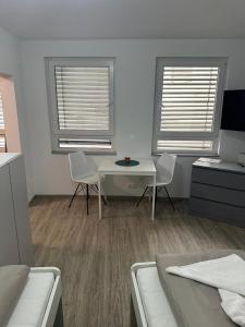 a room with two chairs and a table and two windows at Neckar-Apart in Heilbronn