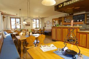 a restaurant with wooden tables and chairs and a counter at Braustüble und Hotel zur Post in Weiler-Simmerberg