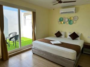 a bedroom with a bed and a sliding glass door at Hotel Ramakrishna in Mahabalipuram