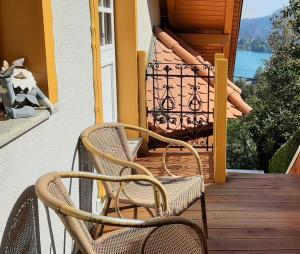 two wicker chairs sitting on a wooden porch at Apartment Milly in Bled