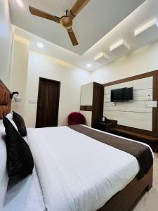 Schlafzimmer mit einem Bett und einem Flachbild-TV in der Unterkunft HOTEL MONGA 5 Minutes From Golden Temple in Amritsar
