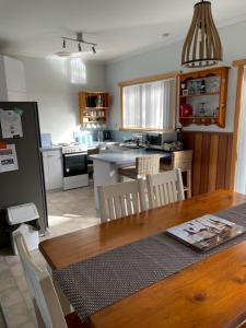 cocina con mesa de madera y comedor en ‘Rose Cottage’ sisters beach accommodation, en Sisters Beach