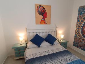 ein Schlafzimmer mit einem Bett mit zwei Nachttischen und zwei Lampen in der Unterkunft APARTMENT WITH SINGLE ROOMS in Algodonales
