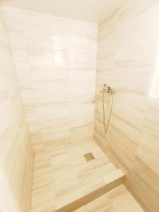 a bathroom with a shower with a wooden floor at Студії біля Радіозаводу in Ivano-Frankivsʼk