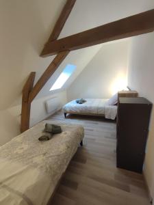 1 dormitorio en el ático con 2 camas y ventana en 2 Chambres, Confort et Calme. en Zeggers-Cappel