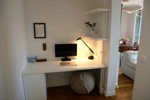 een bureau met een computer in de woonkamer bij Champerret in Parijs