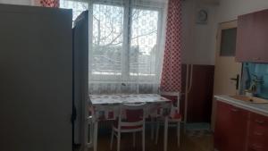 Una cocina con una mesa y sillas frente a una ventana. en Zolo dom, en Liptovský Mikuláš