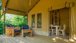 布里亞爾的住宿－Camping le Martinet，帐篷在甲板上配有桌椅