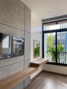 a living room with a large window and a bench at Thành Thuý Hotel in Buon Ma Thuot