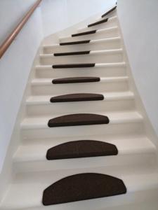 a white staircase with black treads and rocks at Sandra in Leoben