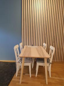 a wooden table and chairs in front of a wall at Apartma Oskar Mariborsko Pohorje in Hočko Pohorje