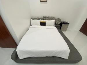 1 dormitorio con 1 cama grande con sábanas y almohadas blancas en Q Beach Resort en Cabangan