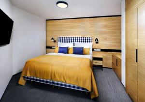 a bedroom with a large bed with blue pillows at Hotel Galeria Thermal Bešeňová in Bešeňová