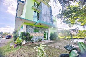 Casa verde y blanca con ventana en Charlz Angel Inn, en Iloilo City