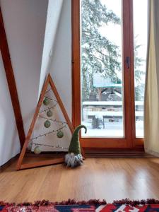 a christmas tree in a triangle next to a window at Chalet Tupara in Vlasic