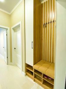 a room with a closet with a bench in it at apartment Tandau Astana in Taldykolʼ