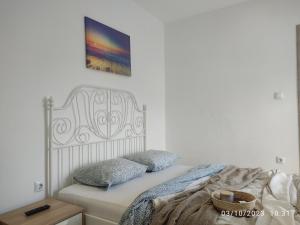 a bed with two pillows and a painting on the wall at Budget Studio by the Sea in Perea