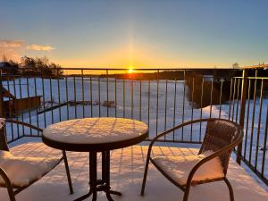 einen Tisch und Stühle auf einem Balkon mit Blick auf den Sonnenuntergang in der Unterkunft Pensjonat Rybical in Ryn