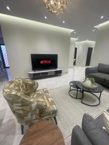 شقة فاخرة للعوائل دور ارضي مع فناء خارجي في Riyadh Al Khabra: غرفة معيشة مع تلفزيون وأريكة وطاولة
