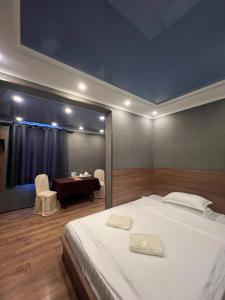 比什凯克Salut Hotel的一间卧室，配有一张床和一张桌子和椅子 更多37张照片