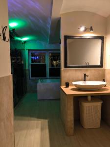 a bathroom with a sink and a large mirror at Apartma in wellness Čista fantazija in Velika Polana
