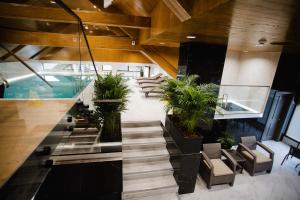 un vestíbulo con escaleras y sillas y una piscina en Podina Resort Hotel & Spa, en Ungureni