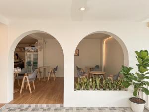 uma sala de estar com dois arcos com mesas e cadeiras em Le soleil koh Larn em Ko Larn