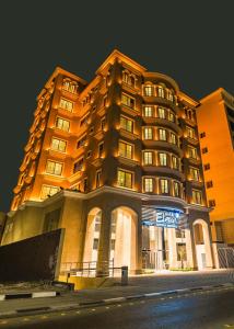 un grande edificio è illuminato di notte di فنـــــــــدق ايليفــــــــــــار Elevar Hotel a Al Khobar